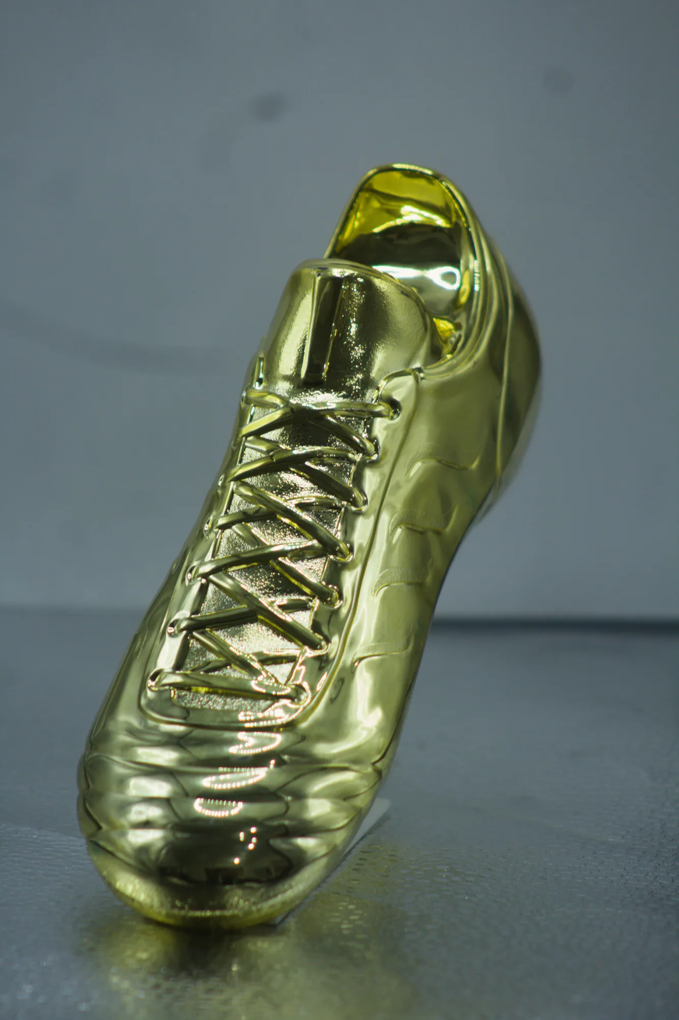 Troféu em forma de chuteira com acabamento dourado polido